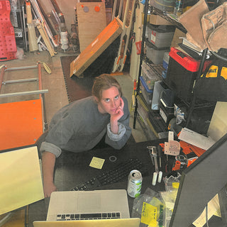Photograph of Somato’s founder, Hannah Fink, in her garage workshop, prototyping the reformer in the company’s early days.
