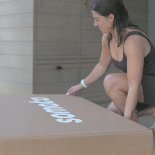 Excited customer opening the box of her newly delivered Somato Reformer.